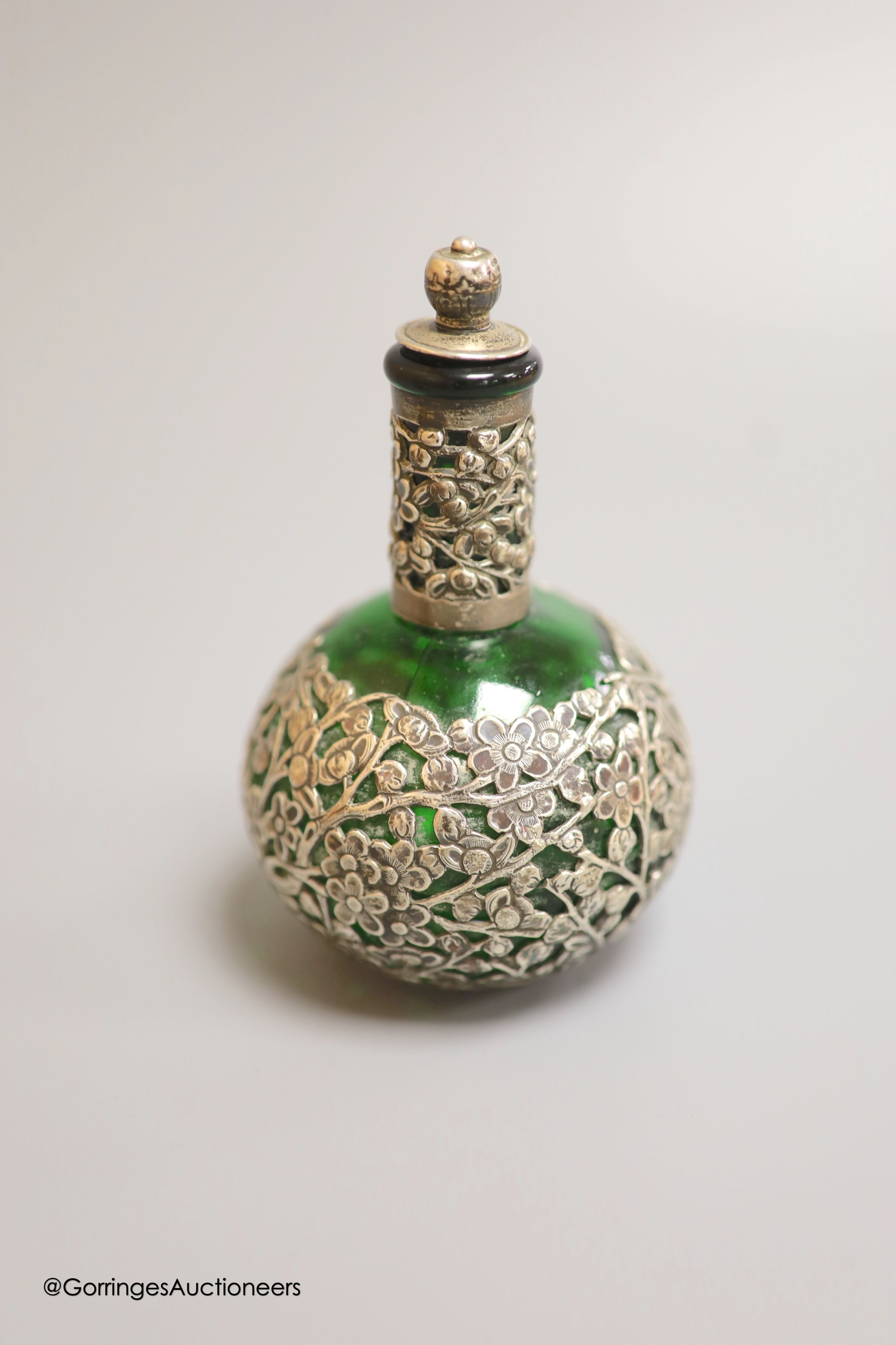 A late 19th/early 20th century Chinese Export white metal circular box, by Wang Hing, embossed with dragons, diameter 5cm, together with a similar white metal overlaid green glass scent flask by Wang Hing, height 11.6cm.